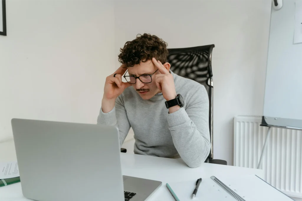 improve bad credit by thinking and brainstorming sample image of a man infront of laptop thinking deeply