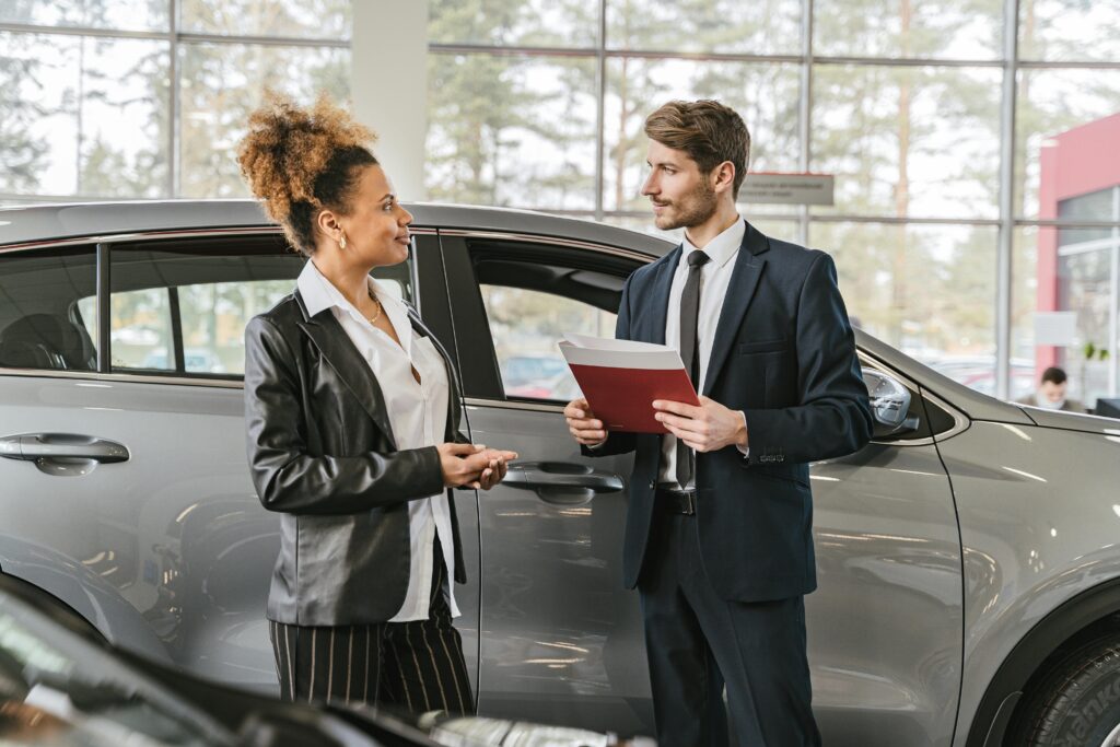 car dealership image of two persons discussing about car loan approval tips