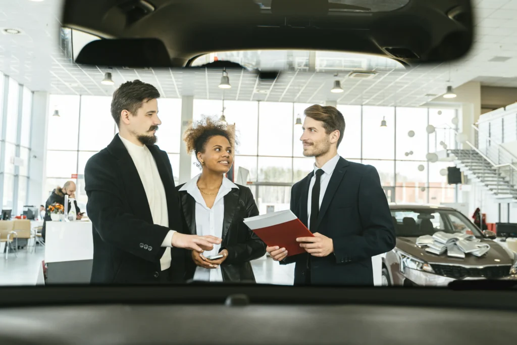 married couple trying to apply for a car loan inside a car dealership