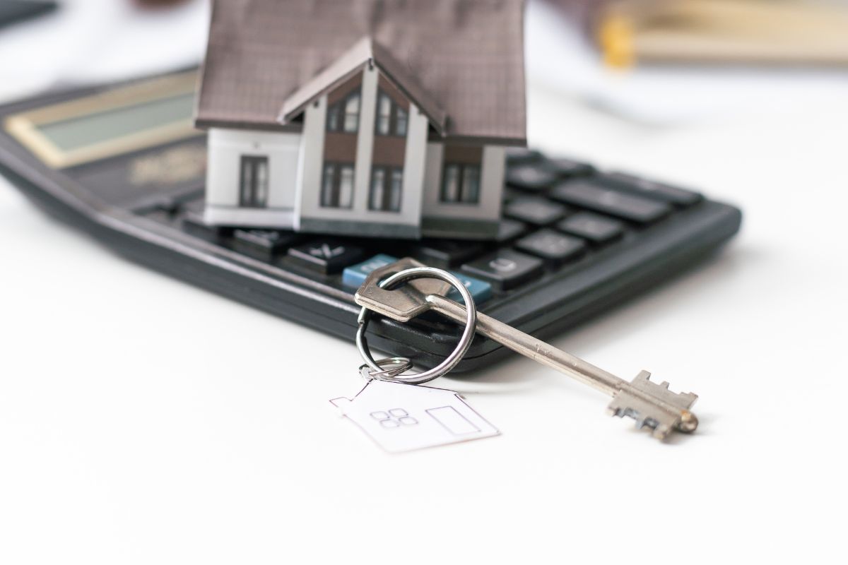 First Home Buyer Deposit Brisbane - a small stack of coins showing the minimum deposit to buy a home beside a house key